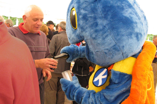 A large blue turtle pours wine